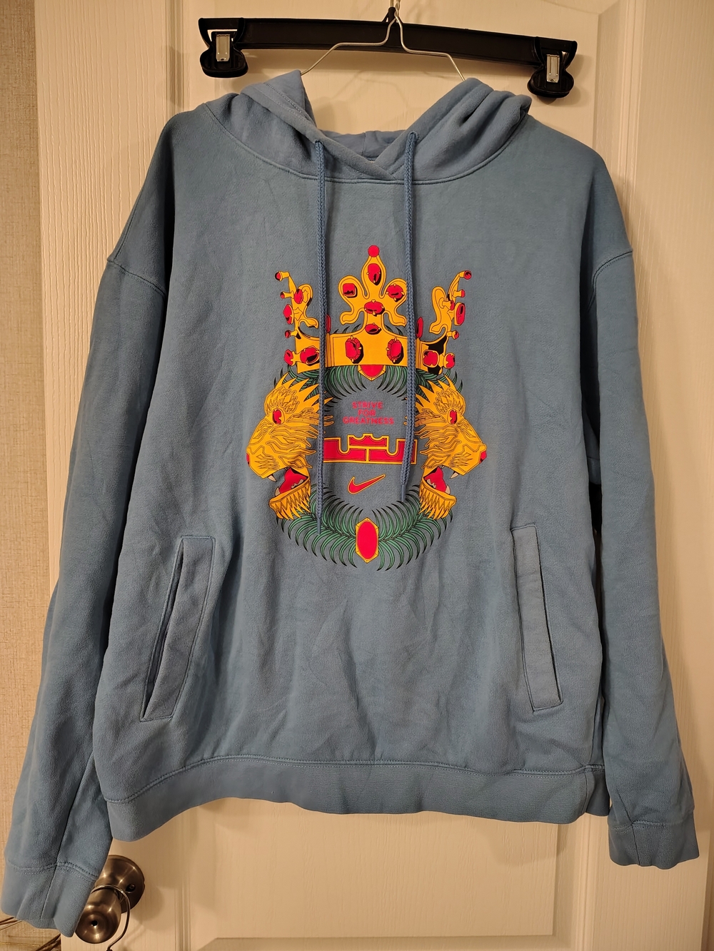 Nike Light Blue Hoodie with Yellow & Red Crest Graphic
